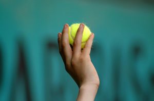 Kinderhand und Tennisball